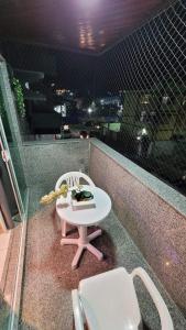 einen kleinen Tisch und Stühle auf dem Balkon in der Unterkunft Apartamento CABO FRIO - PRAIA DO FORTE in Cabo Frio