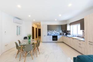 cocina y comedor con mesa y sillas en H2 -Modern and Spacious 3 Bedroom Apartment, en San Ġwann