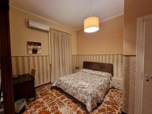 een slaapkamer met een bed en een lamp erin bij B&B Elisa in Crotone