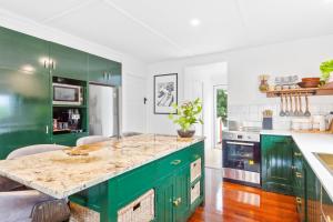 a kitchen with green cabinets and a counter top at Cooee Bay Beach House in Yeppoon
