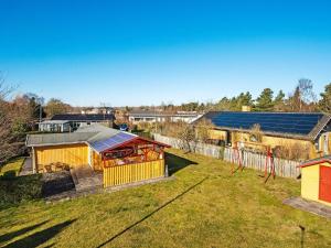 een uitzicht op een achtertuin met een huis en een speeltuin bij Holiday home Juelsminde XCI in Sønderby
