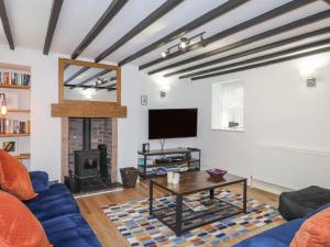 ein Wohnzimmer mit einem blauen Sofa und einem Kamin in der Unterkunft Rowarth in Pwllheli