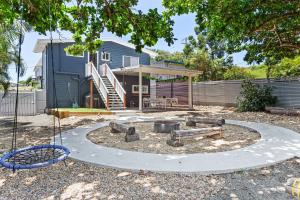 a backyard with a fire pit and a house at Cooee Bay Beach House in Yeppoon