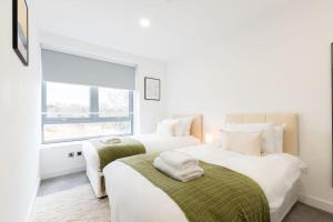 2 letti bianchi in una camera con finestra di Coral - 2 Bedroom Flat a Bracknell