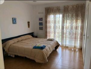 ein Schlafzimmer mit einem großen Bett und einem großen Fenster in der Unterkunft Cortijo la Umbria in Villanueva de Algaidas