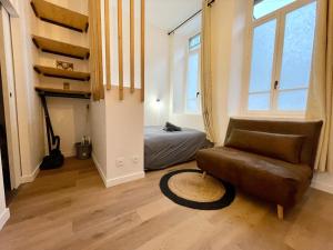 a living room with a couch and a bed at LE VOLTA - Appartement - Centre ville Calais in Calais