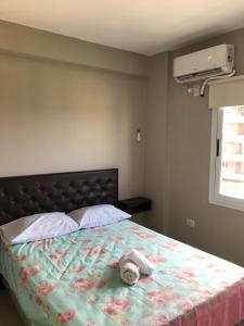 un dormitorio con una cama con un animal de peluche en Depto en Tucumán en San Miguel de Tucumán