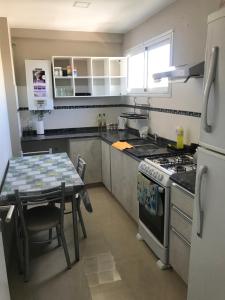 a kitchen with a table and a stove and a sink at Depto en Tucumán in San Miguel de Tucumán