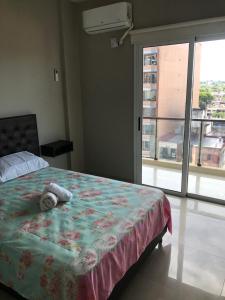 um quarto com uma cama e uma grande janela em Depto en Tucumán em San Miguel de Tucumán