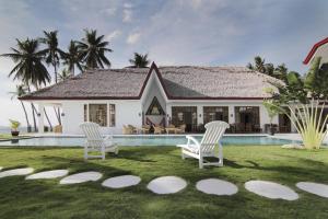 a house with a yard with two chairs and a pool at Sea Dream Resorts in Dauin