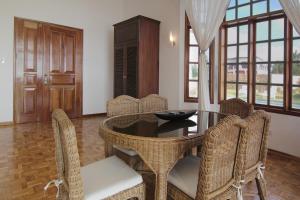 a dining room with a table and wicker chairs at Sea Dream Resorts in Dauin