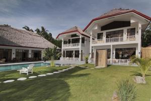 a villa with a swimming pool and a yard at Sea Dream Resorts in Dauin