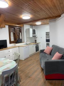uma sala de estar com um sofá e uma cozinha em Casa Alba em Taull
