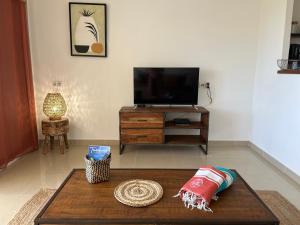 sala de estar con TV y mesa de centro en Le Baileys - Spacieux appartement en rez-de-jardin vue lagon, en Marigot