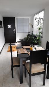 a dining room with a black table and chairs at Aptos para tus vacaciones a 3 min del Parque del Cafe in Armenia