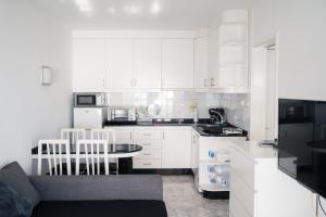 una cocina con armarios blancos y electrodomésticos en blanco y negro en Sunset Place, en Mogán