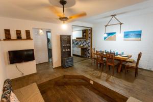 a living room with a table and a dining room at Paraíso Azul - Praia de Barequeçaba in Barequeçaba +41 photos