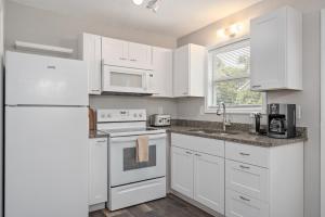 a kitchen with white cabinets and a white refrigerator at Beach Twin B KDH123B in Kill Devil Hills