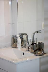 encimera con lavabo y espejo en Gamay Souterrain Apartment, near beach in Curaçao, en Jan Thiel