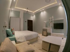 um quarto com uma cama, uma televisão e um sofá em Dive Hostel Hurghada em Hurghada