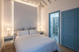 サンタ・クルス・デ・ラ・パルマにあるVivienda Vacacional Don Pedroのベッドルーム(白い大型ベッド1台、青いドア付)