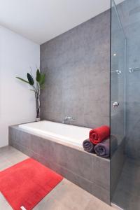 a bathroom with a tub and a red rug at Amaroo in Queenscliff