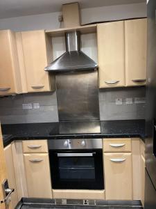 a kitchen with a stove and a hood at Entire house with parking in Manchester