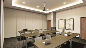 a conference room with tables and chairs with laptops at AC Hotel by Marriott Saltillo in Saltillo