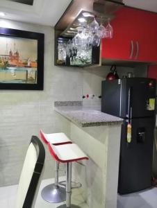 a small kitchen with a counter and a refrigerator at Casa en Villa Carolina in Barranquilla