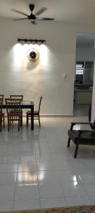 a dining room with tables and chairs and a ceiling fan at Kerian Putra Muslimstay in Parit Buntar