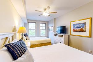 a bedroom with two beds and a flat screen tv at Baytowne Wharf - Observation Point North #460 in Destin