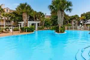 a large swimming pool with palm trees in a resort at Baytowne Wharf - Observation Point North #460 in Destin