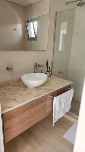 y baño con lavabo blanco y espejo. en Altos de Mendoza en Mendoza