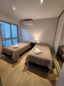 2 camas en una habitación con ventana en Altos de Mendoza en Mendoza