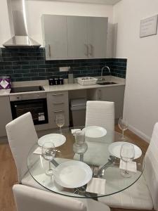 a kitchen with a glass table and white chairs at 004- Brand new 1 bedroom apartment F1 in Ealing