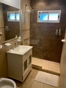 a bathroom with a sink and a shower and a toilet at Hermoso y cómodo dpto c/cochera Tres Arroyos in Tres Arroyos
