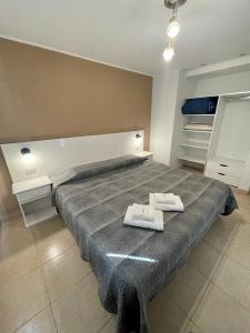 1 dormitorio con 1 cama grande y 2 toallas. en Hermoso y cómodo dpto c/cochera Tres Arroyos en Tres Arroyos