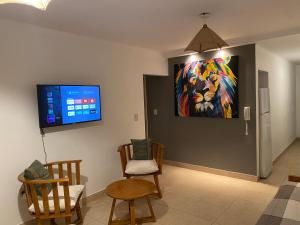 una sala de estar con una pintura en la pared en Hermoso y cómodo dpto c/cochera Tres Arroyos en Tres Arroyos