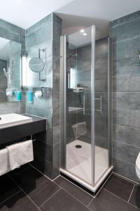 uma casa de banho com um chuveiro e um lavatório. em Best Western Hotel am Europaplatz em Königsbrunn