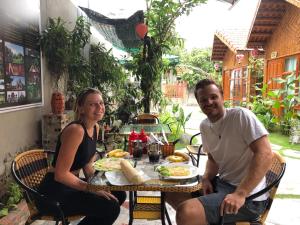 a man and a woman sitting at a table with food at Tam Coc Hello Homestay in Ninh Binh