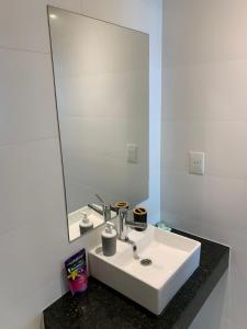 a bathroom with a white sink and a mirror at Hermoso depto. 1 dormitorio- Asuncion- Villa Morra #504 in Asunción