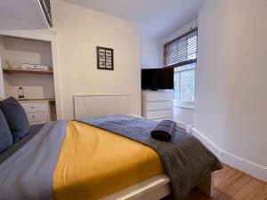 a bedroom with a bed with a yellow blanket at Liberty Street in London