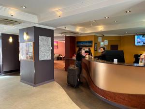 two people standing at a counter in a restaurant at Stay at Alice Springs Hotel in Alice Springs