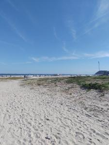 a sandy beach with a group of people in the distance at Pousada do Ade in Ilha do Mel