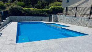 a swimming pool with blue water in a yard at Blueys Beach Villa Manyana 24 in Blueys Beach +5 photos