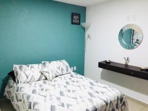 a bedroom with a bed with a blue wall and a mirror at Tu refugio en CDMX cerca del Foro Sol y del AICM in Mexico City
