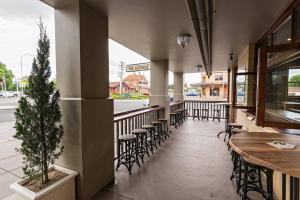 un restaurante con mesas y sillas y un árbol en maceta en The George Hotel Bathurst, en Bathurst