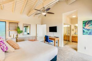 a bedroom with a bed and a desk and a television at Poipu Sands 221 in Koloa