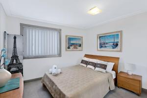 a bedroom with a bed and the eiffel tower at Sandy Cove Apartment The Entrance 17 in The Entrance +4 photos