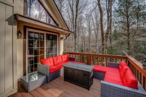 a patio with red cushions and a table on a deck at The Bird House in Dillard
